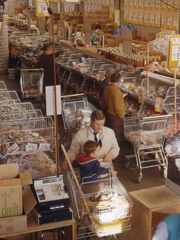 Vader met zoon in winkelwagen in supermarkt 