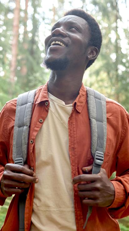 een man kijkt omhoog tijdens een boswandeling