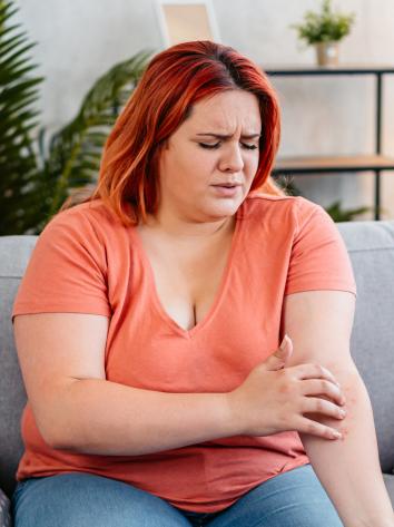 een vrouw zit aan huiduitslag op haar arm
