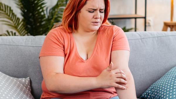 een vrouw zit aan huiduitslag op haar arm