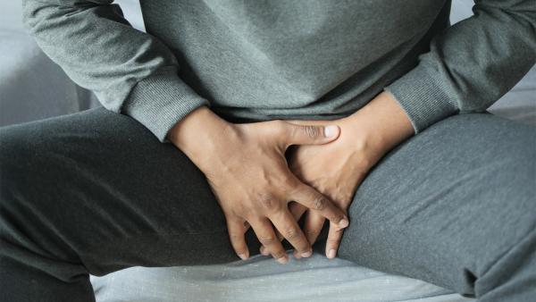 Man grijpt naar zijn kruis