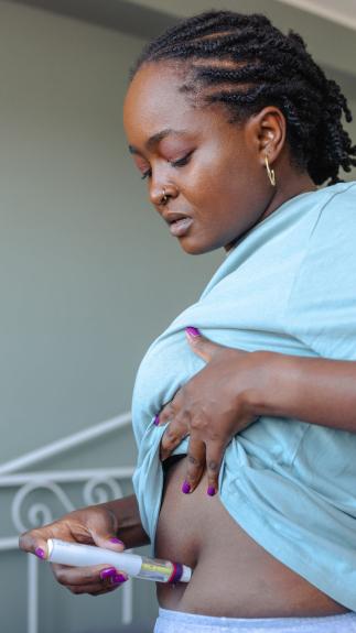 een vrouw injecteert zichzelf in de buik met hormonen 