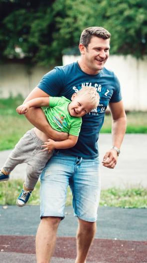 een vader speelt buiten met zijn kinderen