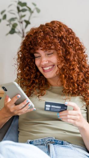 Een vrouw zit vrolijk online te shoppen.