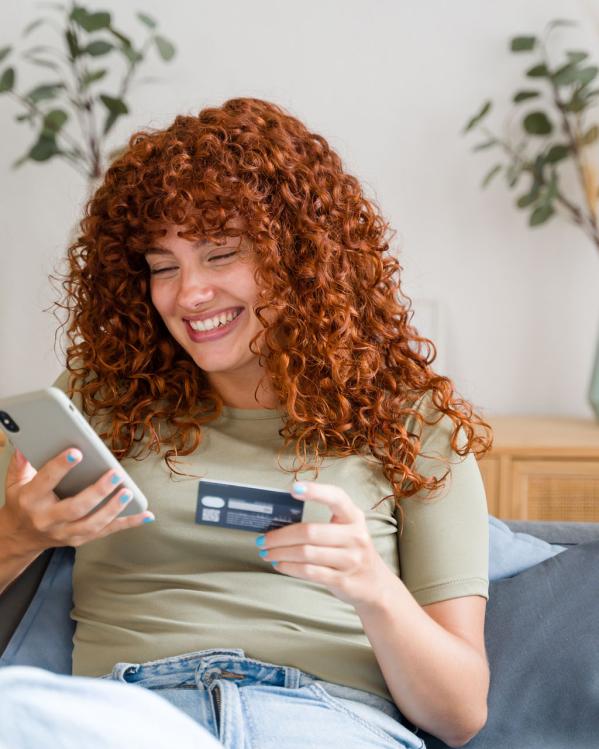 Een vrouw zit vrolijk online te shoppen.