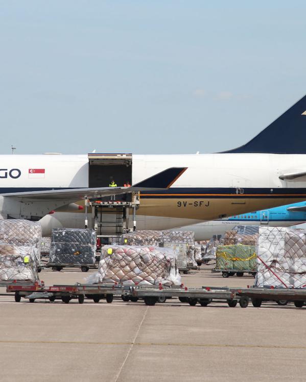 Een lange rij een webshopproducten wordt ingeladen in een vrachtvliegtuig.