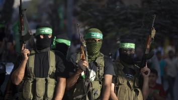 mannen met gezichtsbedekking en groene Hamas hoofdband houden geweren omhoog