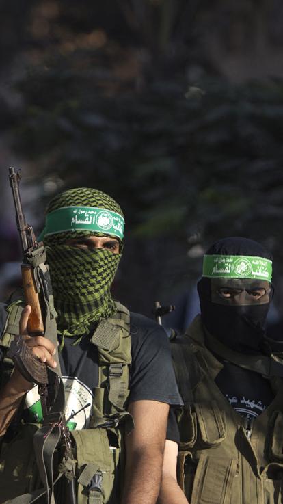 mannen met gezichtsbedekking en groene Hamas hoofdband houden geweren omhoog