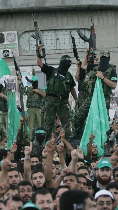 Mannen met groene Hamas vlaggen en gewapende mannen met gezichtsbedekking in legerkleding