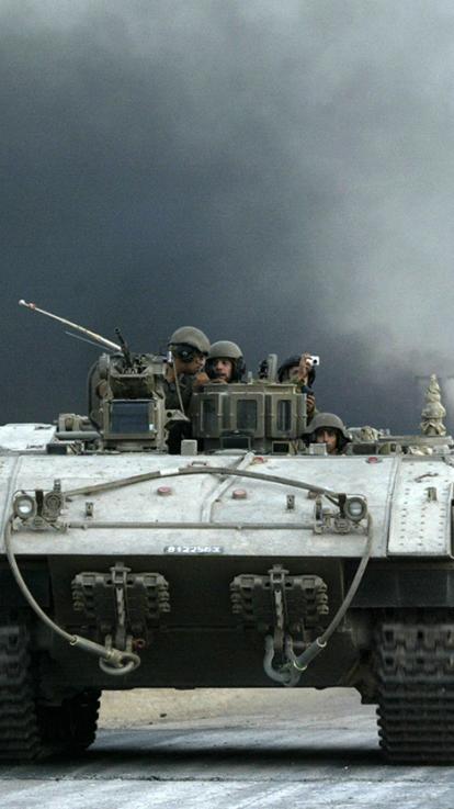 Een rij Israëlische tanks rijdt weg 