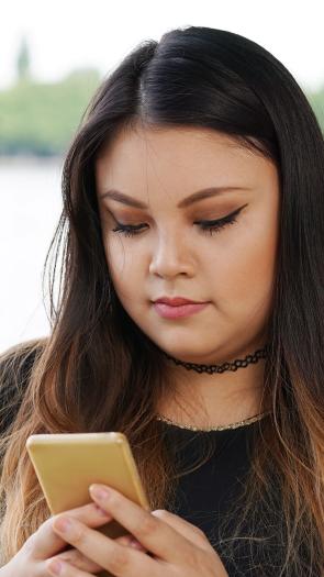 een meisje achter haar telefoon