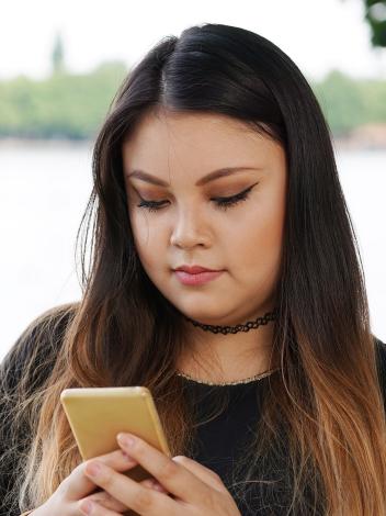 een meisje achter haar telefoon