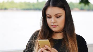 een meisje achter haar telefoon