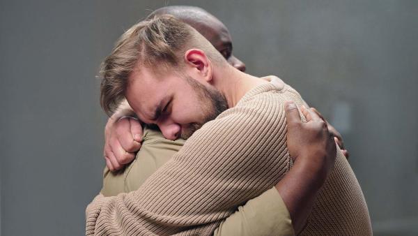 twee mannen knuffelen elkaar