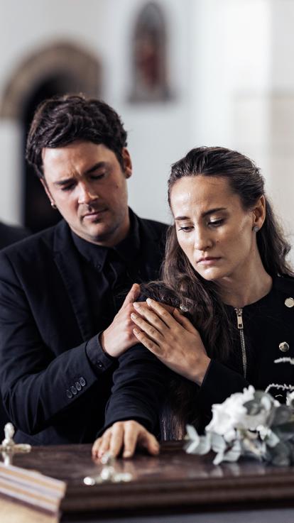 een stel rouwt bij de kist 