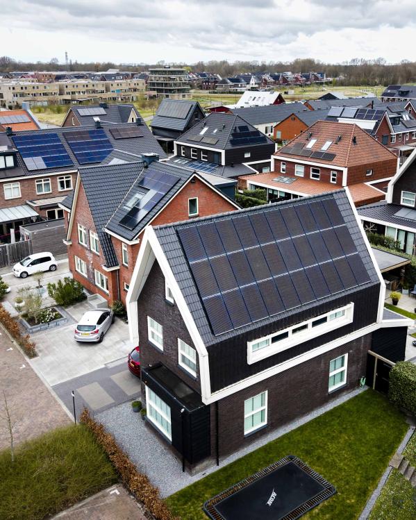 Bovenaanzicht van een nieuwbouwwijk. Elk dak heeft zonnepanelen.