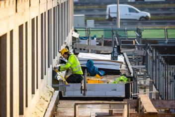 een bouwvakker aan het werk bij een nieuwbouwproject