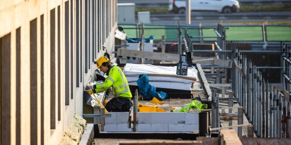 een bouwvakker aan het werk bij een nieuwbouwproject