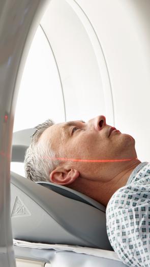 Een foto van een patiënt die in een CT-scanner ligt in het ziekenhuis. 