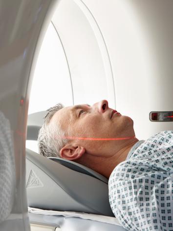 Een foto van een patiënt die in een CT-scanner ligt in het ziekenhuis. 