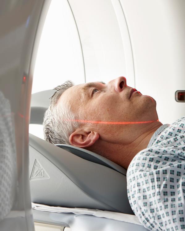 Een foto van een patiënt die in een CT-scanner ligt in het ziekenhuis. 