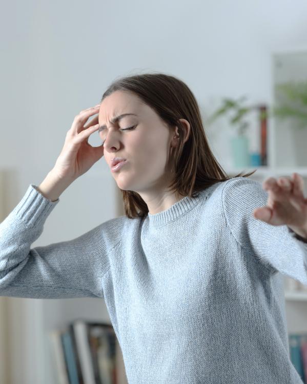 een vrouw met plotselinge hoofdpijn en duizeligheid
