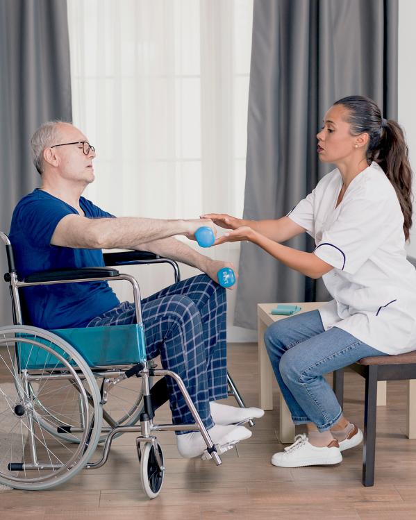 een man in een rolstoel krijgt fysiotherapie