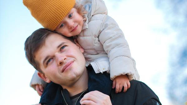 een vader met zijn kind op zijn nek