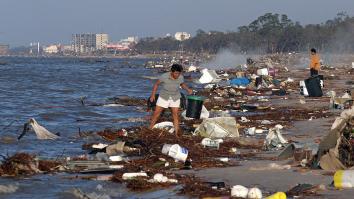 Vrouw zoekt op een strand naar aangespoelde meubels en spullen na orkaan Katrina
