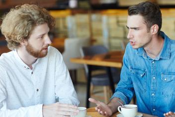 een serieus gesprek tussen twee mannen in een restaurant