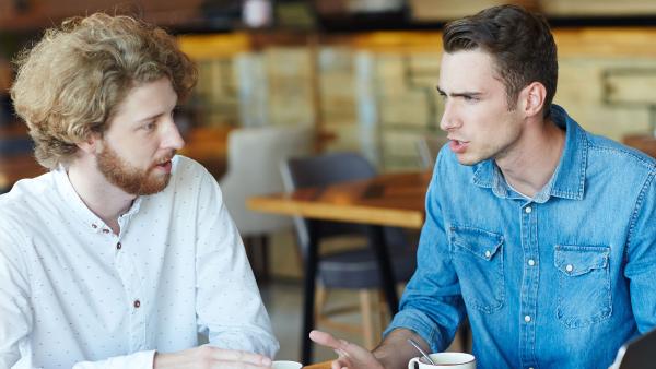 een serieus gesprek tussen twee mannen in een restaurant