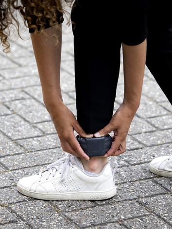 Vrouw bukt voorover en pakt haar enkelband vast