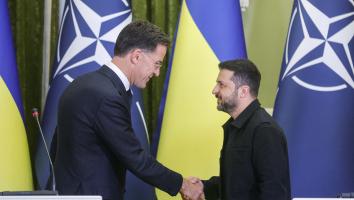 Rutte en Zelensky schudden elkaar de hand voor een Oekraïense vlag.