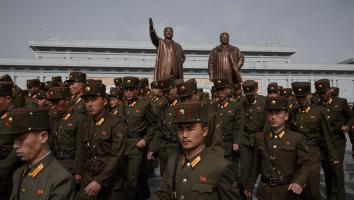 Soldaten lopen langs de standbeelden van Kim Jong-uns voorgangers