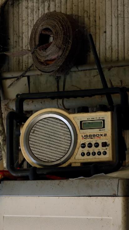 Een foto van een ouderwetse radio in een schuur van een boerderij