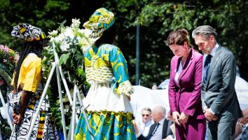 Politici Judith Uitermark en Dick Schoof staan stil voor een krans bij de nationale herdenking slavernijverleden.