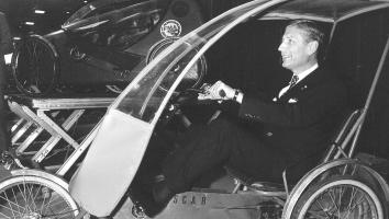 Zwartwitfoto van oud-premier Dries van Agt die in een experimentele fiets zit tijdens een internationaal congres.