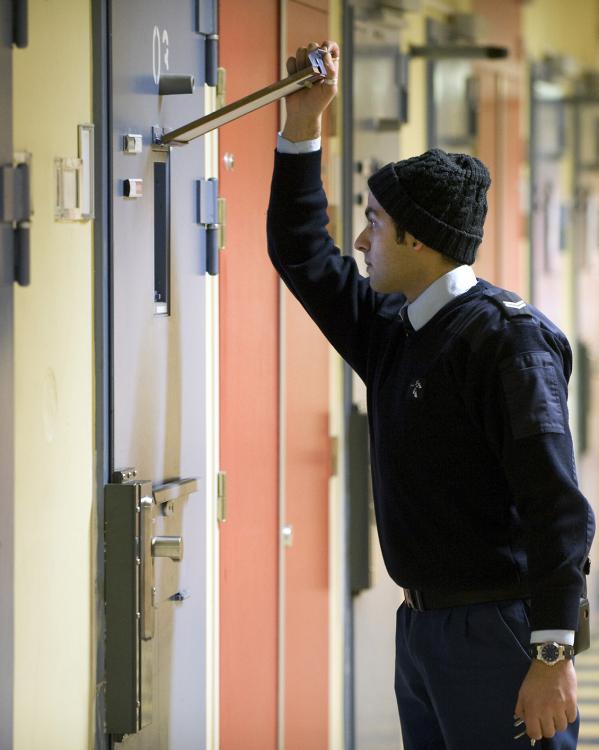 Man die gevangeniscel inkijkt 