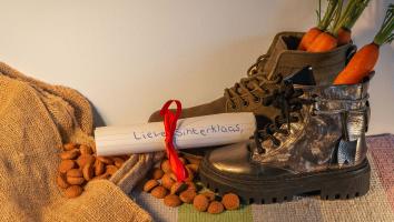 Een paar kinderschoenen met wortels erin. Ernaast een brief voor Sinterklaas en pepernoten.