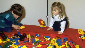 Twee meisjes spelen met lego in de jaren 80, voor hen een grote bak met felgekleurde legostenen.