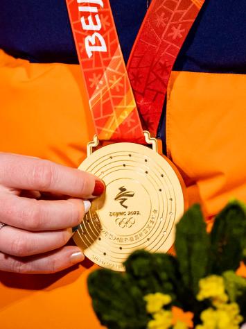 Een hand houdt een gouden plak vast tijdens de Olympische Spelen van Beijing in 2022