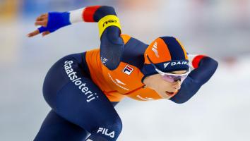 Een close-upfoto van schaatser Femke Kok die geconcentreerd aan het schaatsen is in een wedstrijd