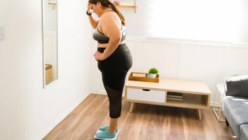 Mevrouw staat op een weegschaal.