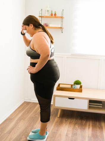 Mevrouw staat op een weegschaal.
