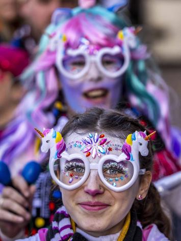 Een foto van een dame die geschminkt is met carnaval. 
