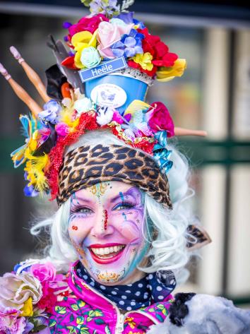 Een vrouw die verkleed is voor carnaval en naar de camera lacht. 