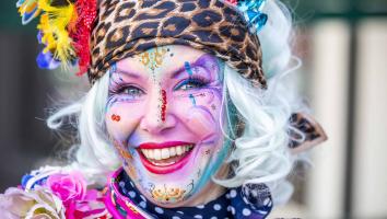 Een vrouw die verkleed is voor carnaval en naar de camera lacht. 