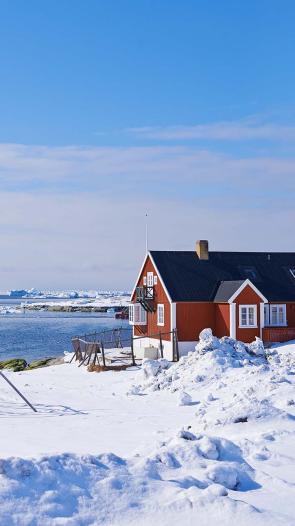 Een klein hutje op een ijzige vlakte op Groenland.