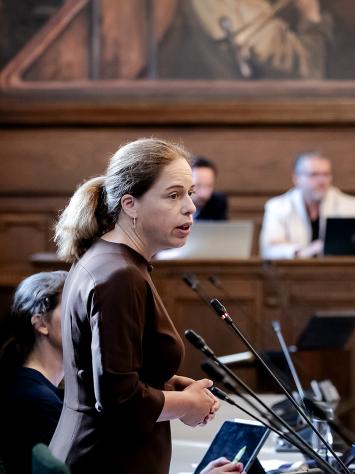 Burgermeester Carola Schouten in de gemeenteraad Rotterdam tijdens een debat staat achter meerdere microfoons