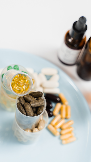 Hand houdt glas water vast naar voedingssupplementen 